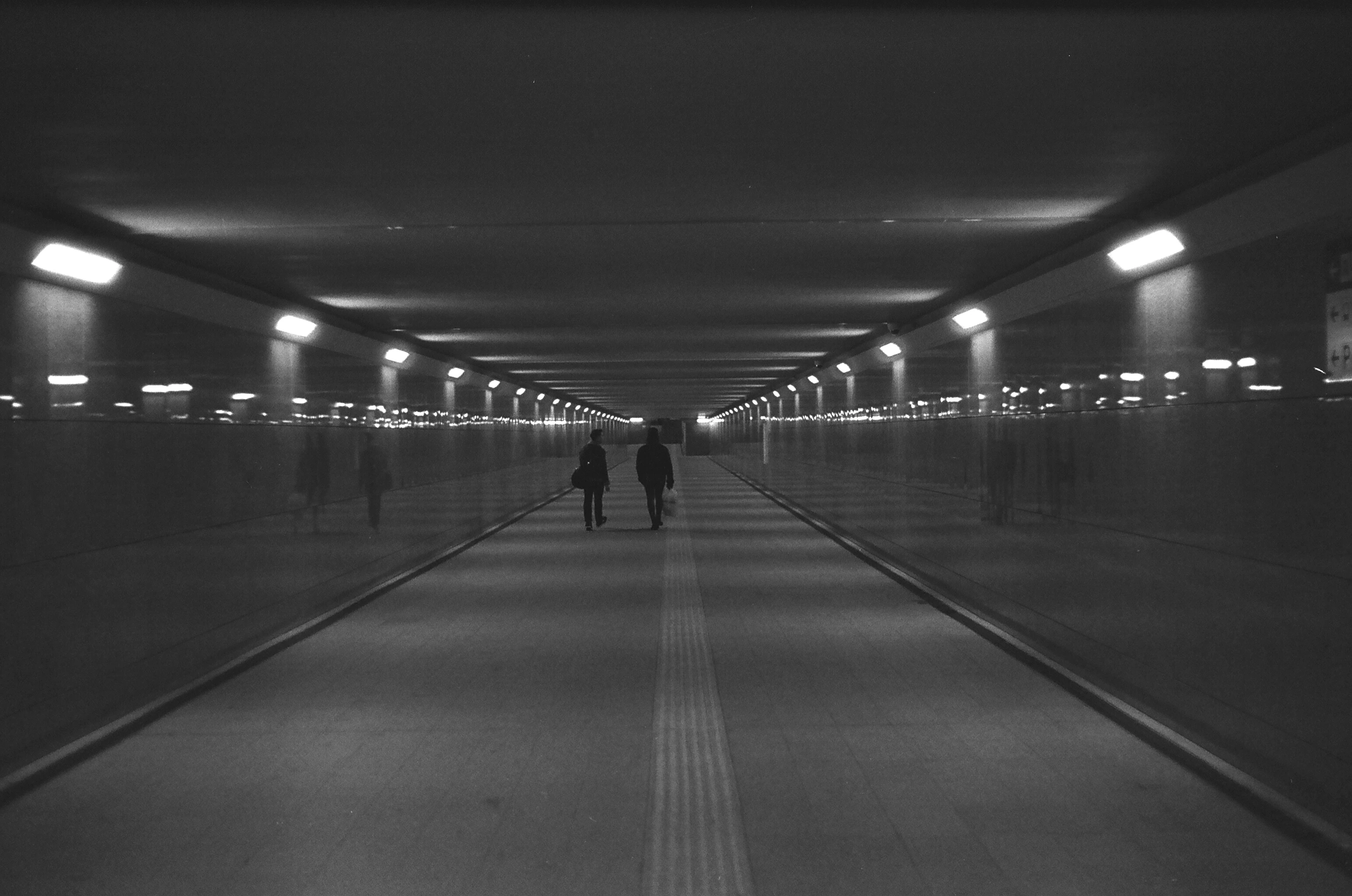Two people walking in a tunnel
